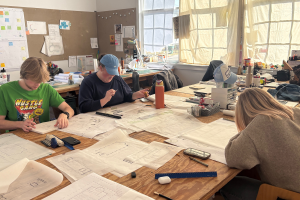 The Church Hall Team works in studio at their desks.